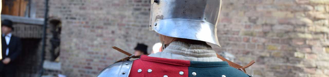 Guerreiro de costas usando um capacete metálico.