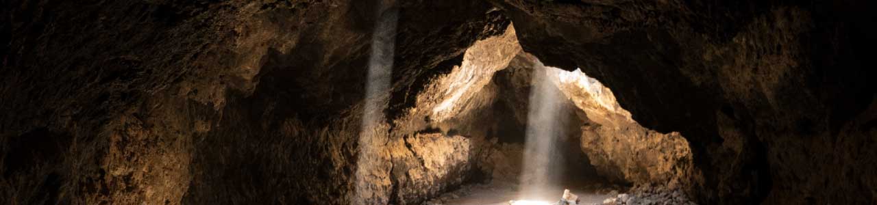 Imagem de uma caverna de pedras com apenas uma brecha de luz, remetendo ao motivo que levou a origem do significado osorio