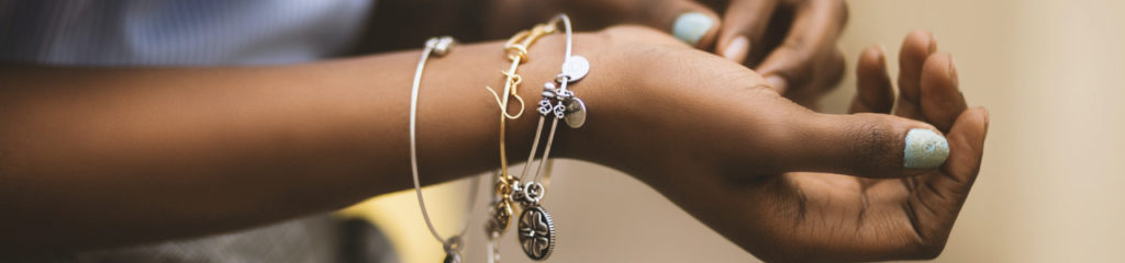 mulher com pulseiras no pulso, fazendo alusão a um dos possíveis significados do nome correia.