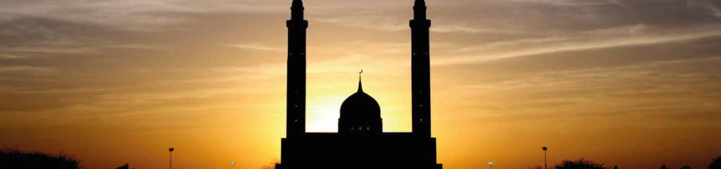 imagem mostra uma mesquita com um lindo pôr do sol ao fundo