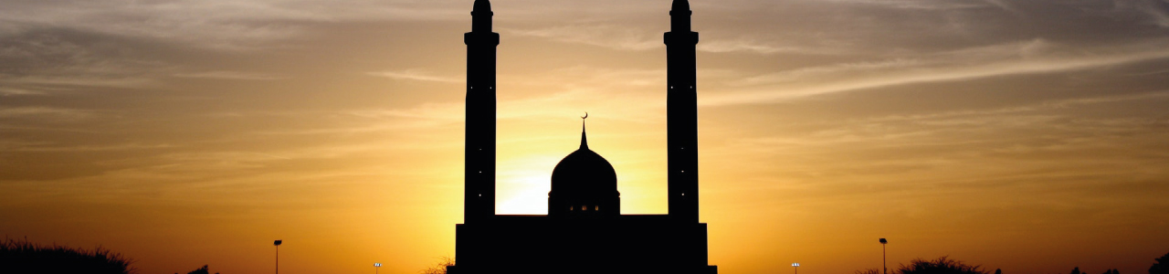 imagem mostra uma mesquita com um lindo pôr do sol ao fundo