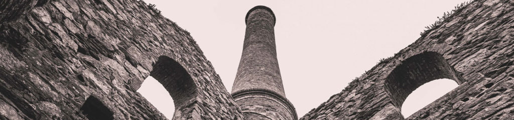 Imagem de uma torre e arcos de pedra.