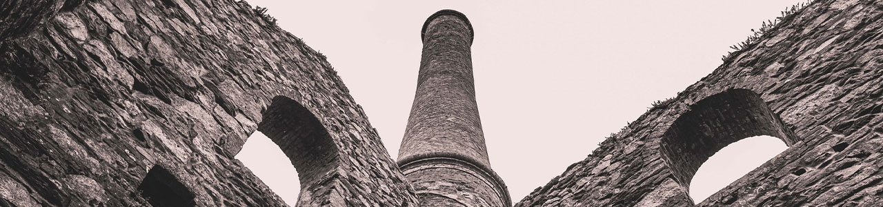 Imagem de uma torre e arcos de pedra.