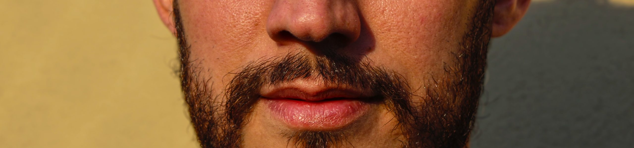 Imagem do rosto de um homem, com detalhe para a boca e o nariz.