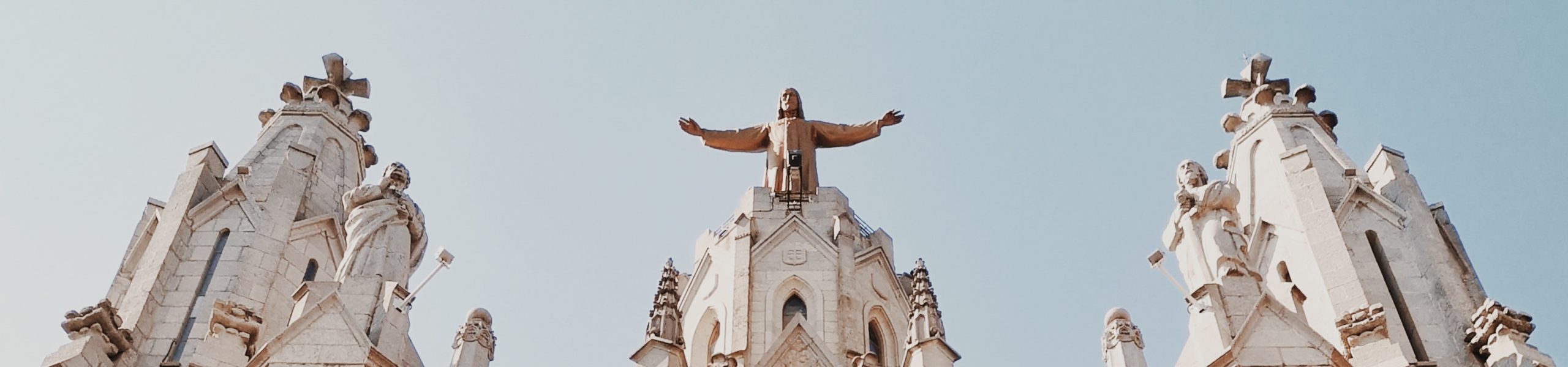 Imagem das torres de uma igreja de blocos brancos, com estátuas de santos.