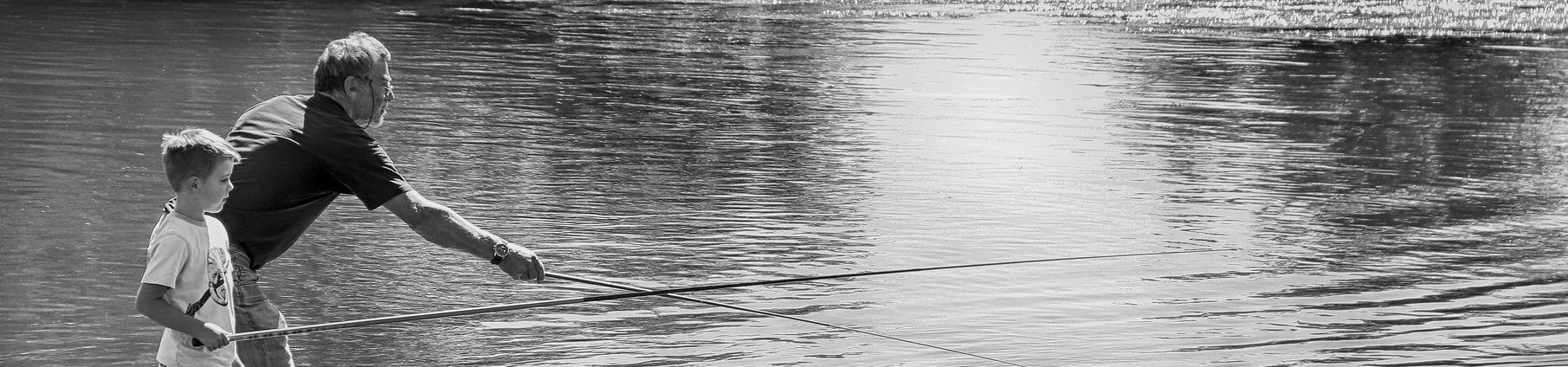 Imagem de um homem idoso pescando com um menino.