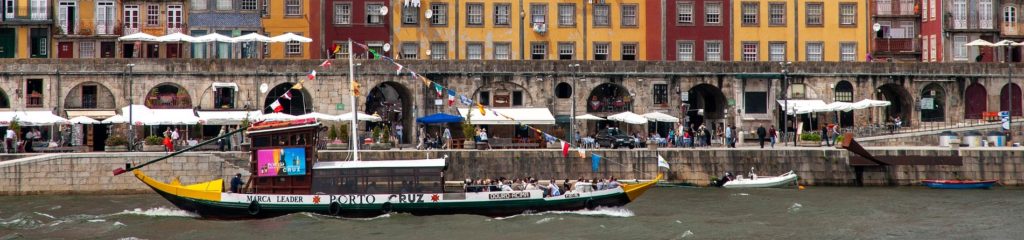 Imagem de um barco, conhecido como rabelo, às margens do rio Douro, em Portugal.