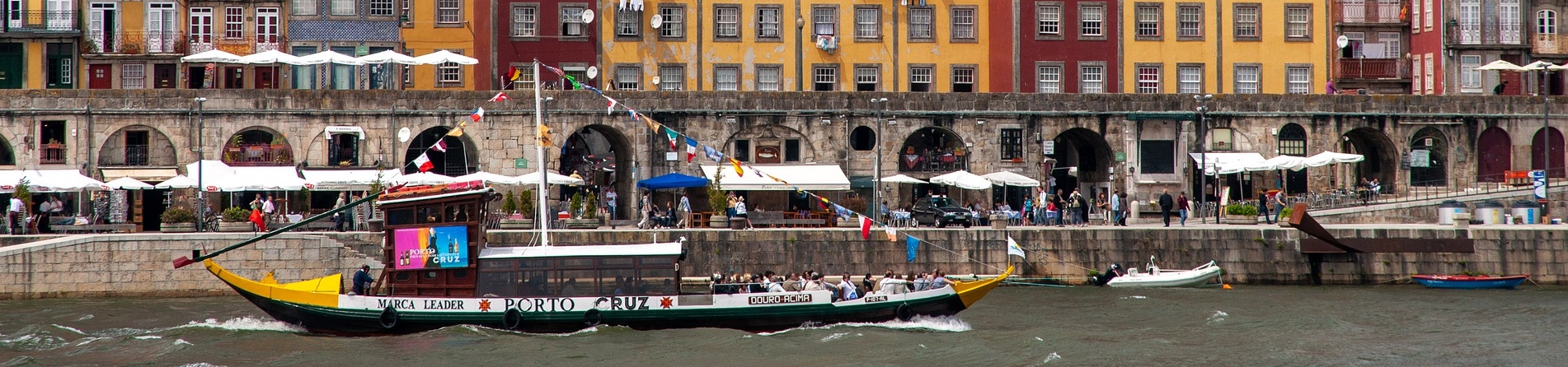 Imagem de um barco, conhecido como rabelo, às margens do rio Douro, em Portugal.