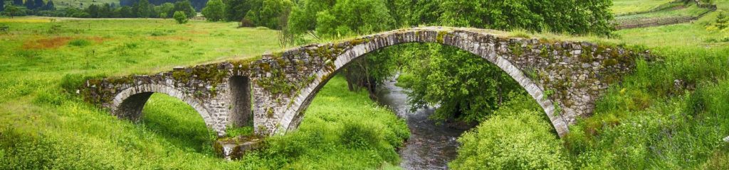 Ponte de pedra sobre um pequeno córrego.