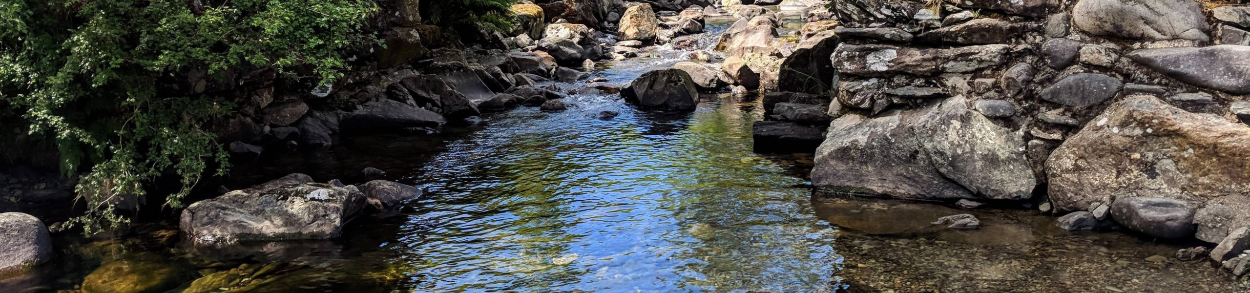 Córrego entre várias rochas na cidade de Ambleside, na Inglaterra.