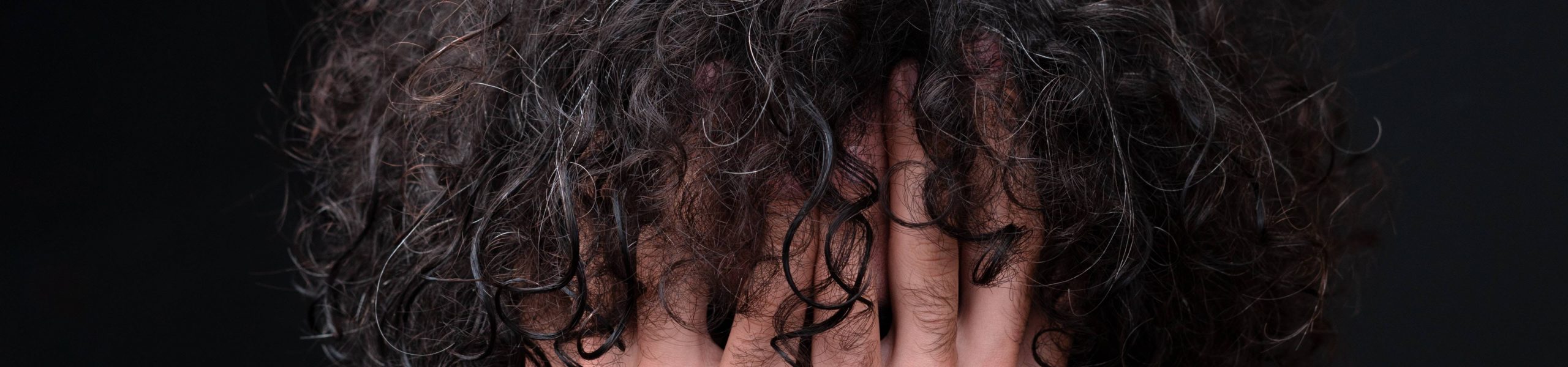 Imagem de um homem com as mãos entre os cabelos.