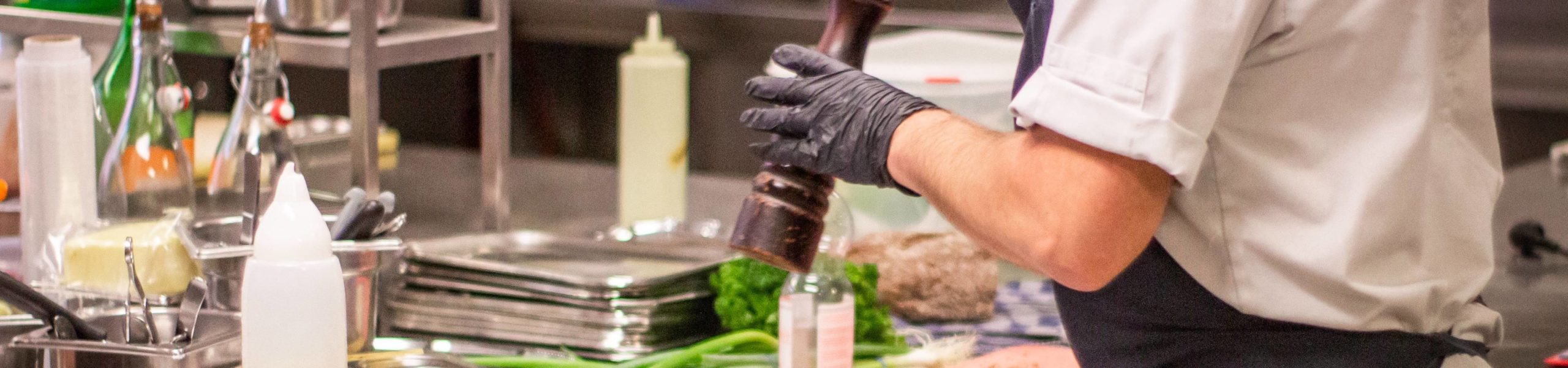 Imagem de um cozinheiro preparando um prato de comida.