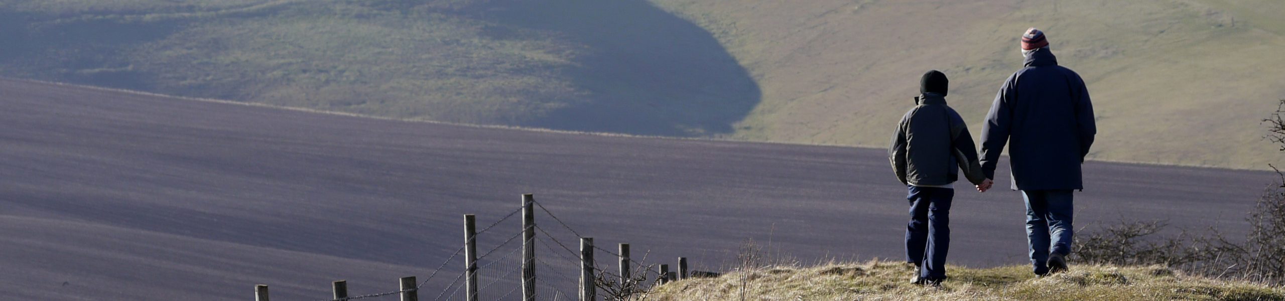 Pai e filho caminhando em uma área de montanhas