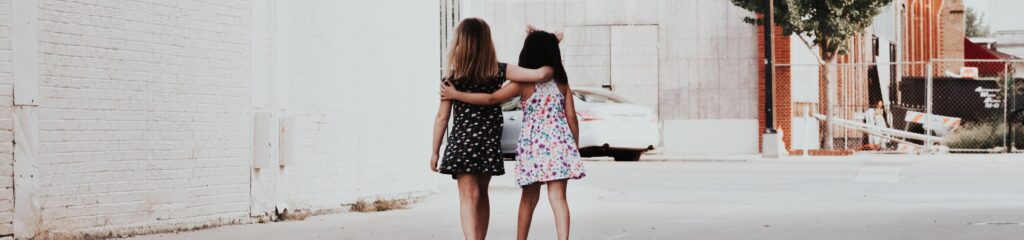 Duas meninas se abraçando em uma rua