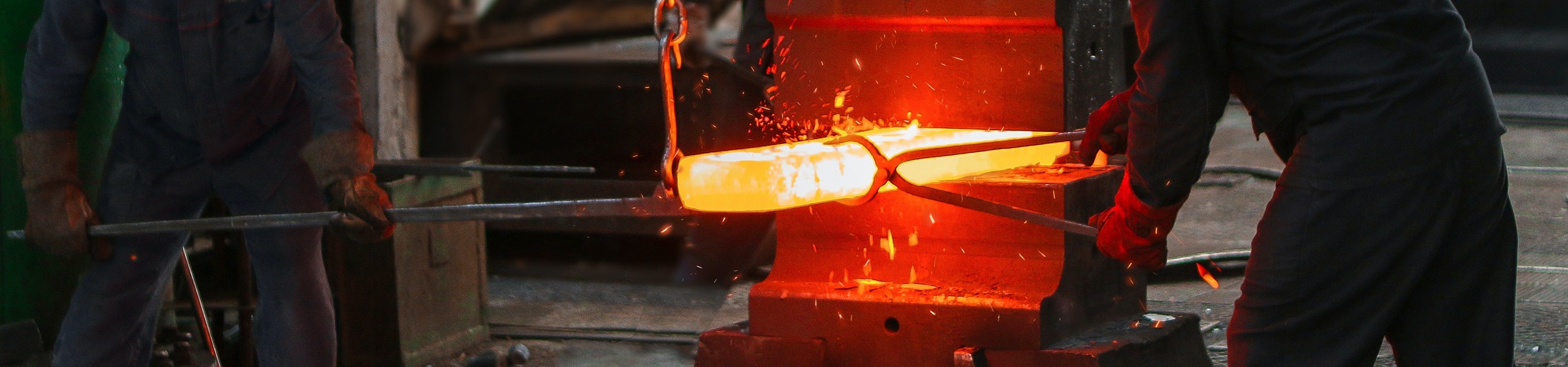 Dois ferreiros trabalhando com uma placa de ferro